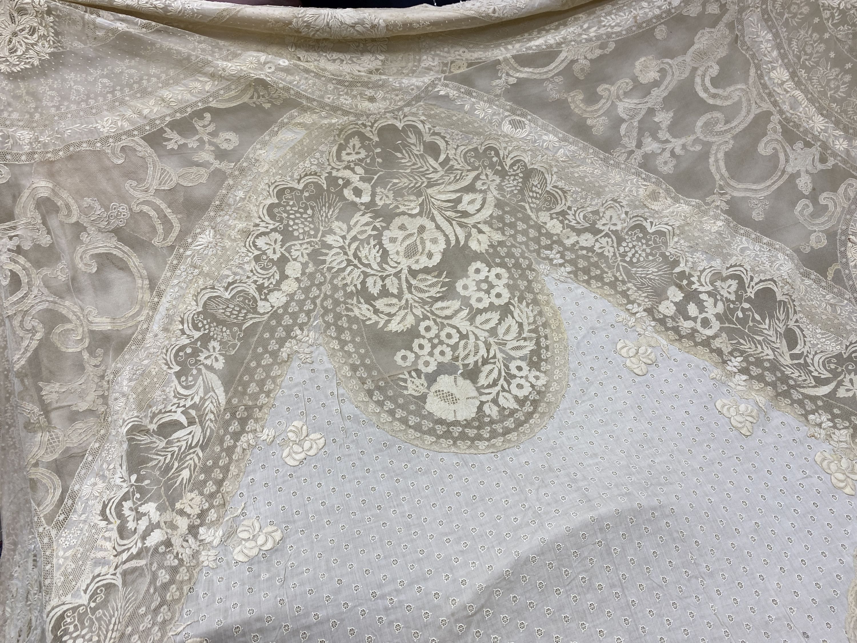 An Edwardian hand made lace bedspread. Hand sewn using finely spun lawn, decorated with Carrickmacross and white work embroidery, edged in bobbin lace. Possibly made as part of a trousseau.